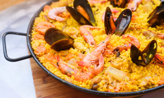 Closeup of a traditional tasty spanish dish paella served with prawns and mussels